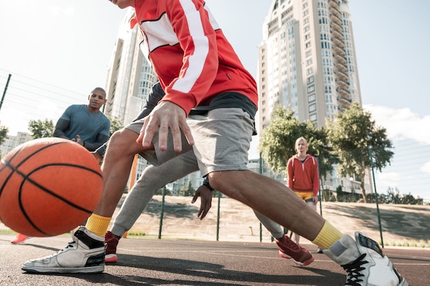 Músculos fuertes. Cerca de fuertes piernas masculinas durante el juego de baloncesto