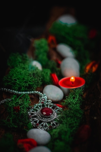 Musgo y piedras verdes del amuleto ritual en la corteza de un árbol en un fondo negro
