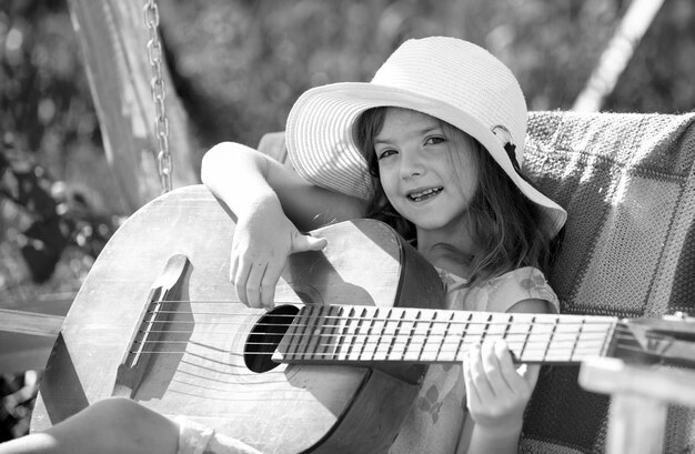 Música y canciones para niños niño pequeño tocando la guitarra moda niño niña niños música guitarra escuela sonriendo