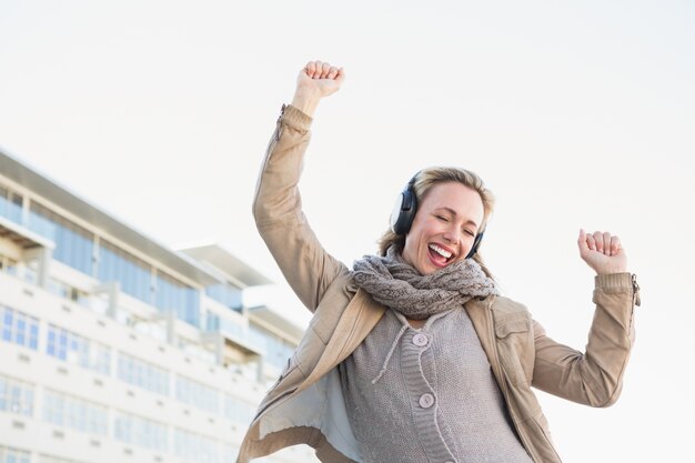 Música de escuta loira feliz com fones de ouvido