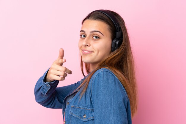 Música de menina adolescente sobre parede rosa isolada