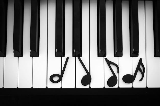 Foto música de nota negra no teclado de piano