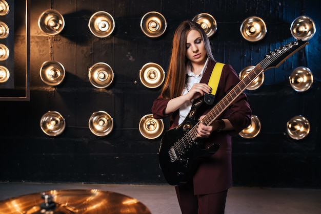 Música feminina de terno tocando guitarra elétrica