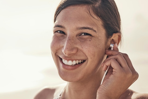 Música de fitness y retrato de mujer en la playa para correr entrenamiento y cardio en el fondo de la maqueta Cara feliz y radio para niña en la naturaleza para ejercicio bienestar y motivación con podcast