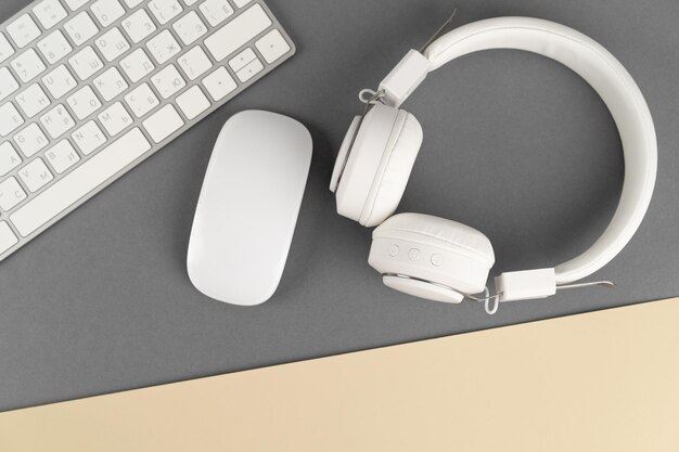 Foto música de fondo o podcast con auriculares y un teclado de computadora en una mesa gris plana diseño plano de vista superior