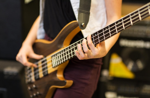 música, gente, instrumentos musicales y concepto de entretenimiento - cerca de músico con guitarra en el estudio de música