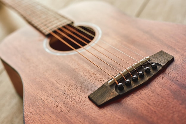 Música de guitarra romántica de cerca la foto de la guitarra acústica marrón tirada en el piso de madera