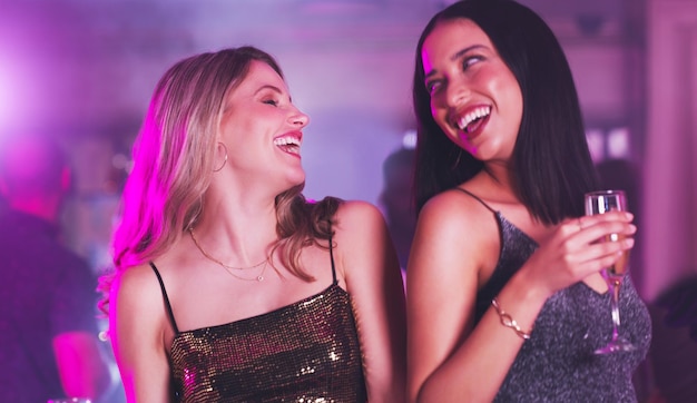 Foto música neon e amigos dançam no clube de festas ou no evento de celebração do ano novo com bebidas alcoólicas ou champanhe energia da vida noturna divertida e mulheres sociais dançando felizes e comemorando na boate discoteca