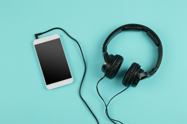 Música on-line conceito phablet e fones de ouvido no fundo de cor