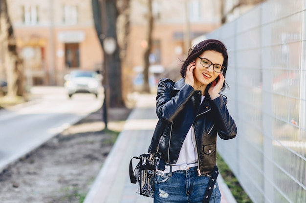 Foto música que escucha divertida de la muchacha atractiva en auriculares