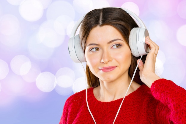 Música que escucha feliz de la mujer joven con los auriculares