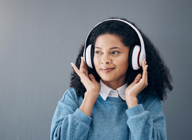 Música relajante y mujer negra en estudio con transmisión de paz o buen humor sobre fondo gris Podcast de radio y chica con mentalidad positiva o audio en línea o lista de reproducción en publicidad de espacios aislados