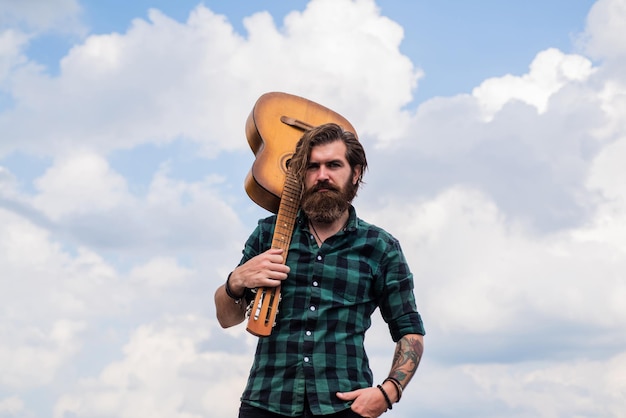 La música te hace más inteligente. Guitarrista de estilo casual. Hipster barbudo de aspecto moderno con concepto de música de guitarra acústica. Hombre guapo brutal con bigote. Toca la guitarra.