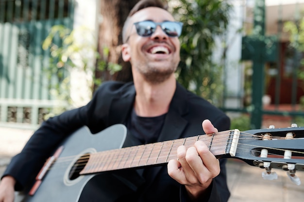 Músico alegre tocando la guitarra