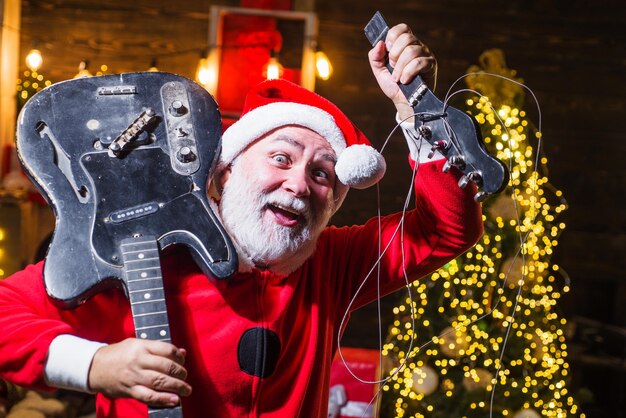 Músico de rock de papai noel com guitarra elétrica quebrada festa de natal e ano novo boas festas