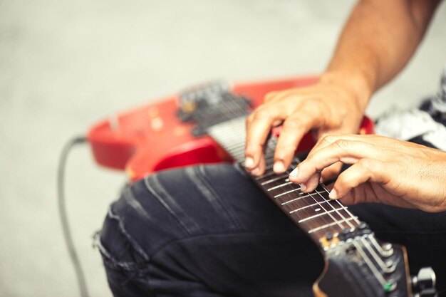 Músico de rua toca guitarra elétrica com os dedos no slide