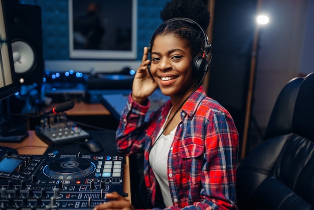 Músico femenino en auriculares en estudio de grabación