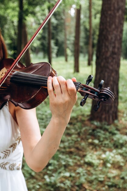 Músico feminino executa em um casamento ao ar livre.