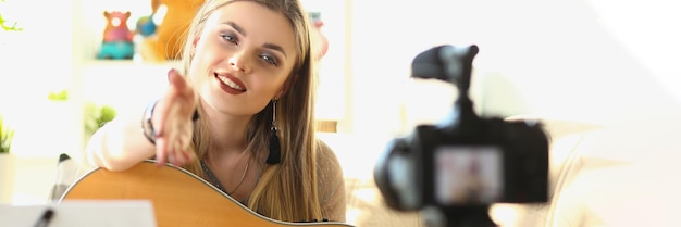 Músico feminino gravando vídeos de ensino de guitarra em close-up