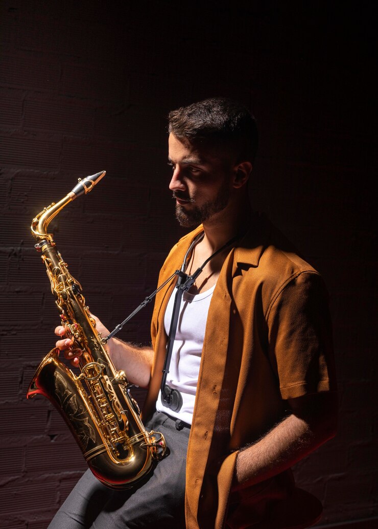 Foto músico en foco sosteniendo un saxofón