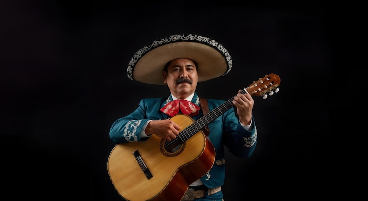 Foto músico de mariachi tocando la guitarra con traje tradicional y sombrero