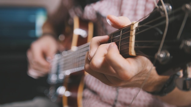 Músico masculino toca la guitarra, manos cerca, concepto de arte