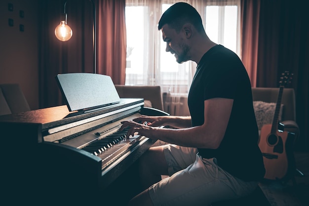 Músico masculino toca piano eletrônico na sala