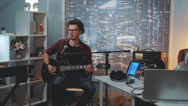 Músico probando equipos de grabación de sonido en estudio casero