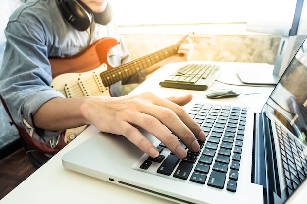 Músico profissional que grava a guitarra elétrica no estúdio digital em casa.