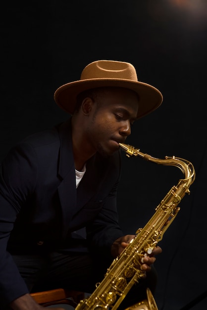 Foto músico talentoso de tiro medio tocando el saxofón.