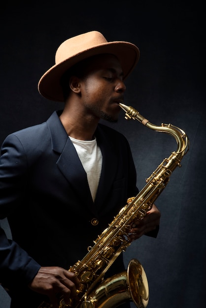 Foto músico de tiro medio tocando el saxofón