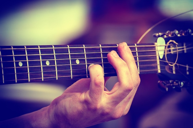 El músico toca la guitarra acústica Primer plano de la mano del músico