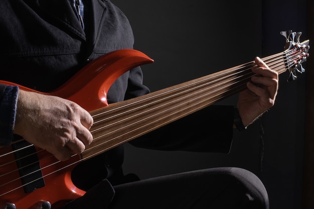 Foto músico tocando baixo violão de seis cordas