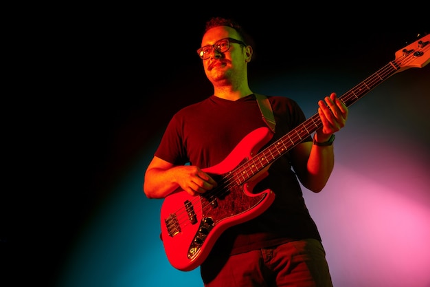 Músico tocando guitarra na luz de néon