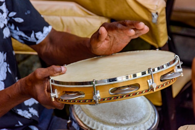 Foto músico tocando tamborim nas ruas de salvador, na bahia, durante uma apresentação de samba