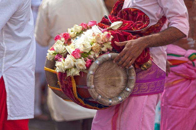 Músico tocando con un Thavil durante una procesión Tamil