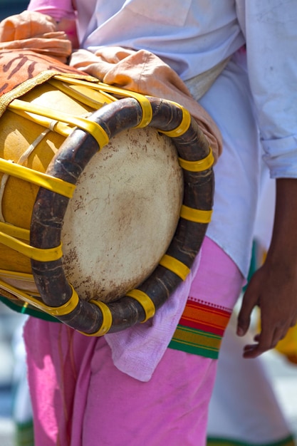 Foto músico tocando con un thavil durante una procesión tamil