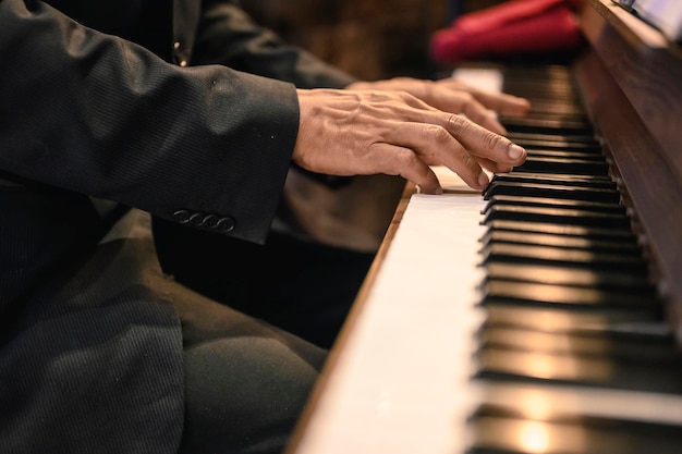 Músicos de primer plano, hombres de mediana edad vestidos con trajes, tocando pianos para edificación y disfrutando de la música alegremente