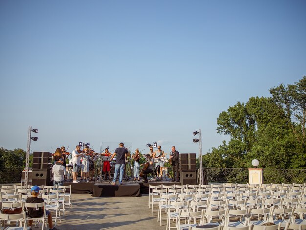 Músicos que interpretan música instrumental clásica en el escenario al aire libre