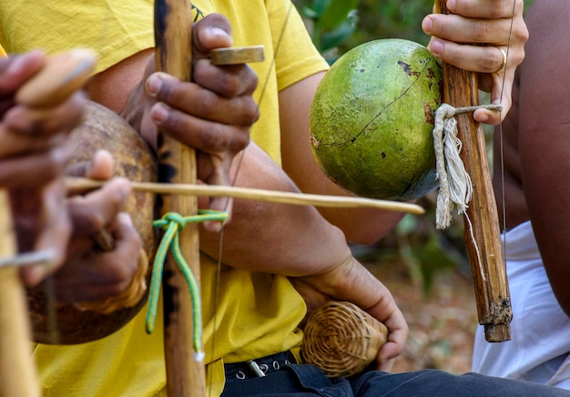 Foto músicos tocando un instrumento llamado berimbau durante una actuación de capoeira en salvador bahia