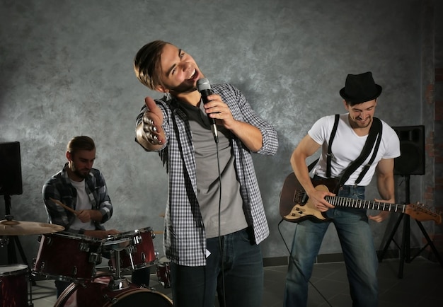 Foto músicos tocando instrumentos musicais e cantando canções em um estúdio