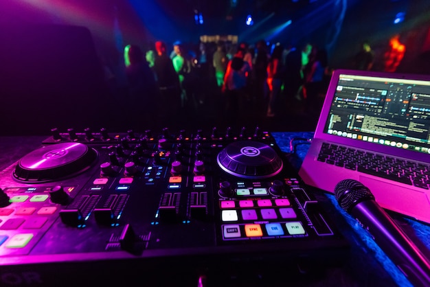 Musik-Controller DJ in der Kabine vor dem Hintergrund der Tanzfläche