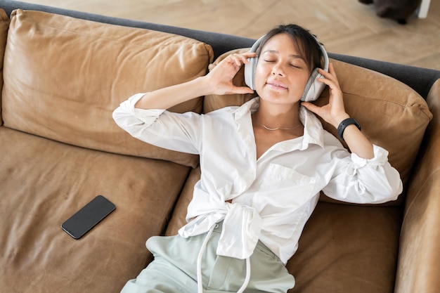 Musik hören mit Kopfhörer Pause Entspannung Eine Freiberuflerin ruht sich auf der Couch aus