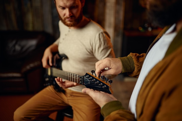 Musiker, der männlichen Studenten beibringt, Gitarre zu spielen