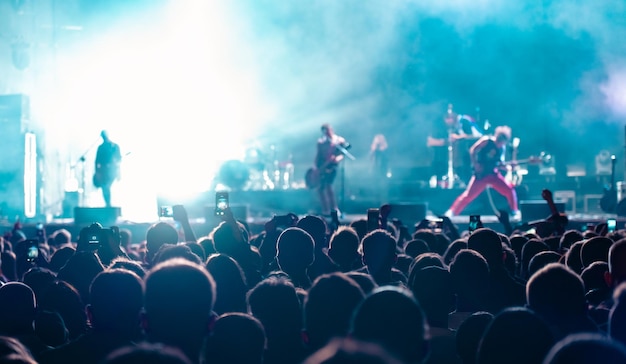 Musikfans nehmen auf einem Konzertfestival im Publikum Videos mit dem Telefon auf