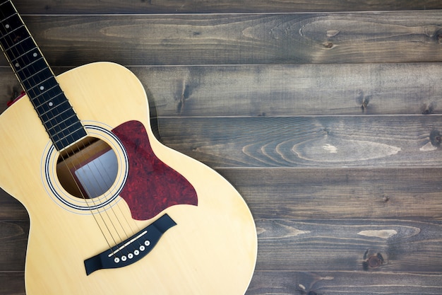 Musikinstrumentgitarre auf altem hölzernem Hintergrund mit Kopienraum. Vintage-Effekt.