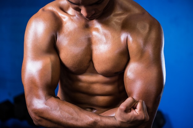 Muskulöser hemdloser Mann im Fitnessstudio