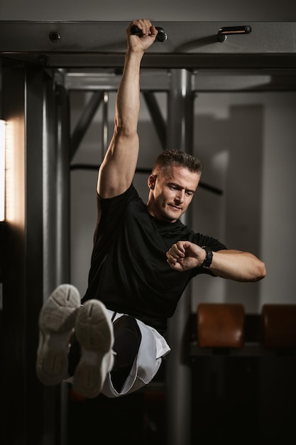 Muskulöser junger Mann in Sportbekleidung konzentrierte sich auf Sit-up-Übungen während eines Krafttrainings im Fitnessstudio.