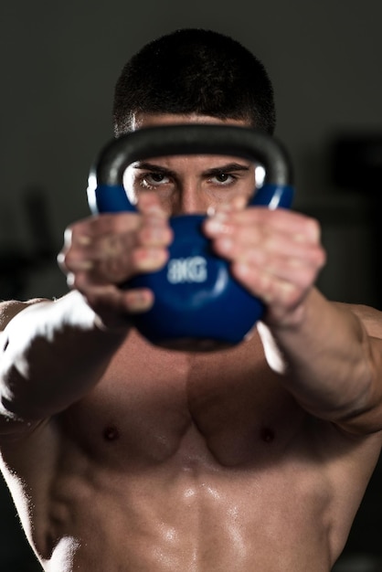 Muskulöser Mann Übung mit KettleBell