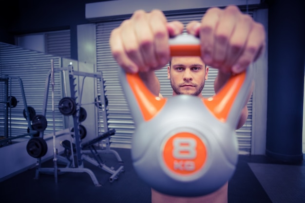 Muskulöser Mann, der ein kettlebell anhebt